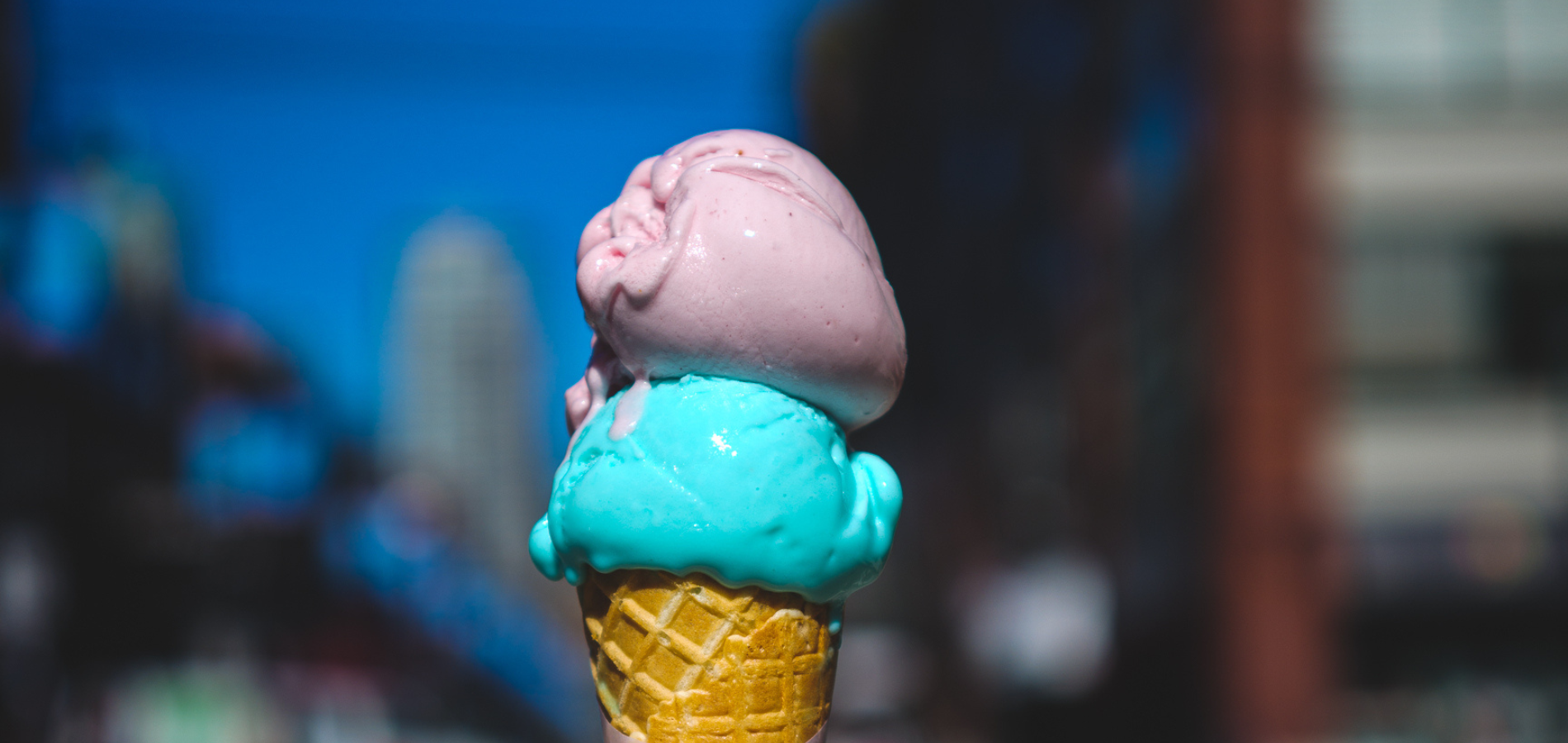 photo of strawberry and birthday cake flavour gelato in cone. Italian gelato is signature product of Tre galli gelato caffe in Vancouver